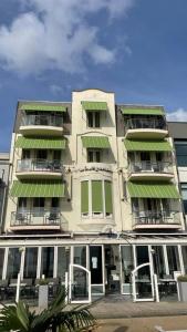 弗利辛恩德罗跟纳尔酒店的一座高大的白色建筑,有绿色遮阳篷