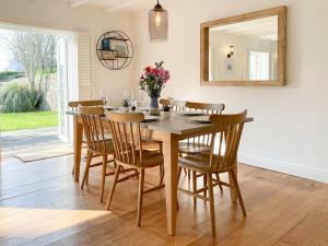 Saint MawganBarn Cottage的餐桌、椅子和镜子