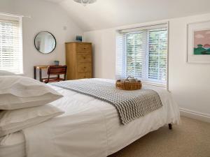 Saint MawganBarn Cottage的一间白色卧室,配有一张带篮子的床