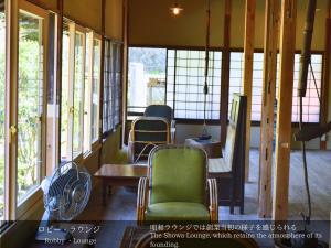 伊豆龙田日式旅馆的配有桌椅和窗户的房间