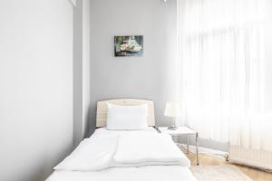 伊斯坦布尔Modern Stylish Cozy Flat in the Heart of Kadikoy的白色卧室配有床和桌子