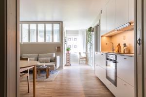 奥斯陆Scandinavian apartment with 2 bedrooms and terrasse - close to Storo Storsenter and all public transport的厨房以及带桌子和沙发的客厅。