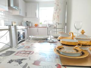 诺丁汉Cosy Family Home in Long Eaton, Nottingham的厨房配有带餐具和玻璃杯的桌子
