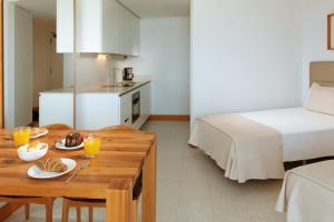 美洲海滩Parque Santiago IV Official的一间房间,配有一张床和一张桌子,上面有食物