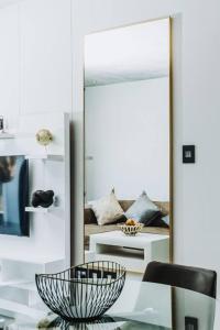 约翰内斯堡Luxury Rosebank Apartment with backup power的镜子和桌子上放着碗