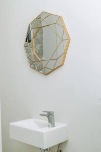 约翰内斯堡Luxury Rosebank Apartment with backup power的浴室水槽上方墙上的镜子