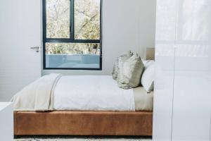 约翰内斯堡Luxury Rosebank Apartment with backup power的一间卧室设有一张床和一个窗口
