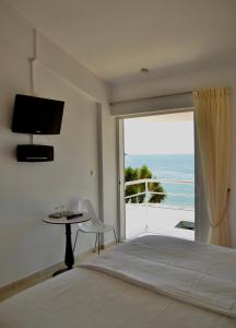 斯基亚索斯镇Anemoni Beach Hotel的一间卧室配有一张床,享有海景