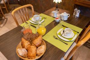圣胡伯特Hôtel Le Cor de Chasse的一张桌子,上面放着一篮面包和橙汁