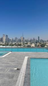 迪拜Al Khoory Courtyard Hotel的一座城市天际线的游泳池