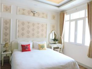 胡志明市CHEZ LOTUS VN的卧室配有白色的床和窗户。