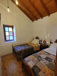 克鲁兹·德·特赫达Finca Ancestros的一间卧室设有两张床和窗户。