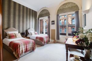 格拉斯哥西乔治街公寓酒店的一间卧室设有两张床和两个窗户。