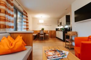 特洛普拉赫Burgls Apartmenthaus的客厅以及带沙发和桌子的厨房。