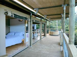 SwanepoelskraalAfriCamps Addo的木制甲板上配有床和桌子