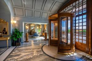 那不勒斯帕克斯大酒店的华丽的大堂设有大窗户和电梯