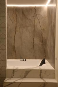 马泰拉艾尔伯格德希迪雷酒店的带浴缸和大理石墙的浴室