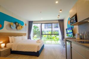 普吉镇HOMA Phuket Town的一间卧室设有一张床和一个大窗户
