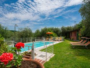 尼阿博勒皮耶韦Holiday Home Colle alla luna by Interhome的鲜花庭院中的游泳池
