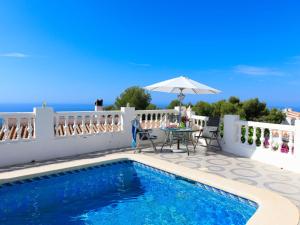 内尔哈Villa Las Brisas by Interhome的别墅配有游泳池、桌子和遮阳伞