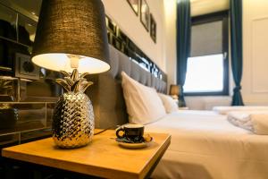 勒沃库森Nikii Boutique Hotel的酒店客房配有一张床和一张带台灯的桌子