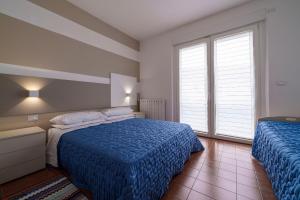 下麦克加诺Casa Vacanza Acqua Dolce的一间卧室设有两张床和窗户。