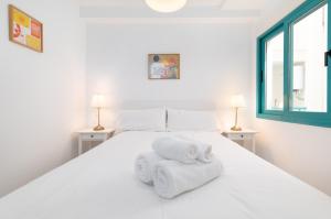 德尼亚Pont Sec Apartments的卧室配有白色床和毛巾