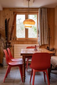 奥尔贝Terre de Sapins的一间带木桌和红色椅子的用餐室