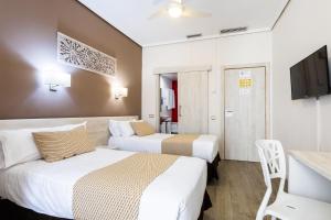 瓦伦西亚甜美大陆酒店的酒店客房设有两张床和电视。