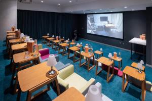 迪拜Studio One Hotel的餐厅设有桌椅和投影屏幕