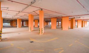 内罗毕钻石广场公寓式酒店的一座建筑里一个空的停车场,里面放着橙色柱子