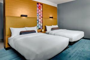 教堂山雅乐轩教堂山酒店的配有白色床单的酒店客房内的两张床
