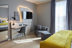 杜塞尔多夫acora Düsseldorf Airport Living the City的一间卧室配有一张床、一张桌子和一把椅子