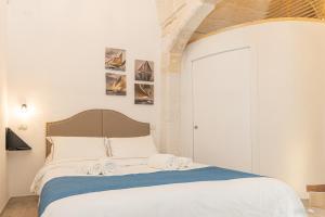 滨海波利尼亚诺Suite Novecento的一间卧室配有一张床,上面有两条毛巾