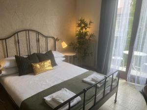 米兰Ambra Boutique Hotel的一间卧室配有带白色床单和金色枕头的床。