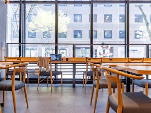 金泽Tokyu Stay Kanazawa的餐厅设有桌椅和窗户。
