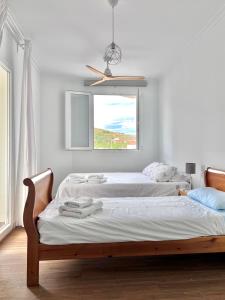 贝莱斯-鲁维奥Ático con Vistas的白色客房的两张床,设有窗户