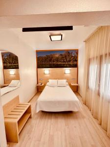 托尔托萨托尔托萨公园酒店的卧室配有一张床,墙上挂有绘画作品