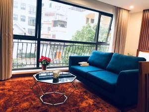 河内Sumitomo10 Apartments Dao Tan的客厅设有蓝色的沙发和大窗户