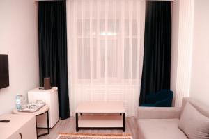博罗沃耶Лечебно-оздоровительный комплекс Ок-Жетпес的带沙发和窗户的客厅