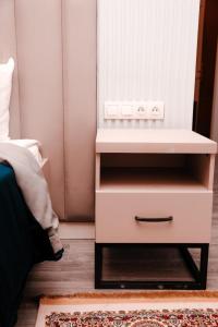 博罗沃耶Лечебно-оздоровительный комплекс Ок-Жетпес的卧室,卧室旁边设有白色床头柜