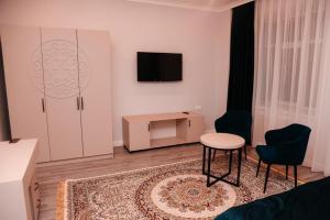 博罗沃耶Лечебно-оздоровительный комплекс Ок-Жетпес的客厅配有电视和桌椅