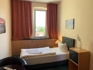 科尔平塞Pension zur Ostsee的一间小卧室,配有一张带窗户的床