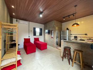 奥林达Loft Menezes Olinda的一间带红色椅子的客厅和一间厨房