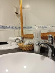 科瓦鲁维亚斯新阿尔兰萨酒店的浴室的柜台设有水槽和镜子