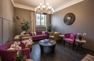 卢塞恩Boutique Hotel KARL的客厅配有紫色家具和吊灯。