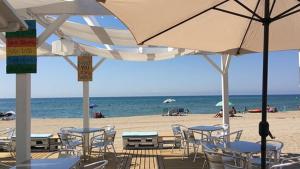 卡拉费尔Apartamento a 20 metros de la playa的海滩上设有桌椅和遮阳伞,还有大海