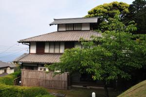 伊东横滨藤吉伊足藤日式旅馆的前面有围栏的房子