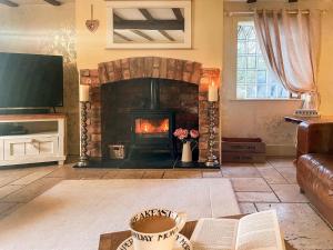 HinstockOld Church Farm的客厅设有壁炉和电视。