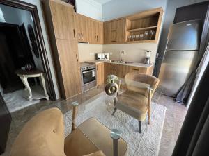 卡尔帕索斯APARTMENT DOWNTOWN的厨房配有木制橱柜、桌子和椅子